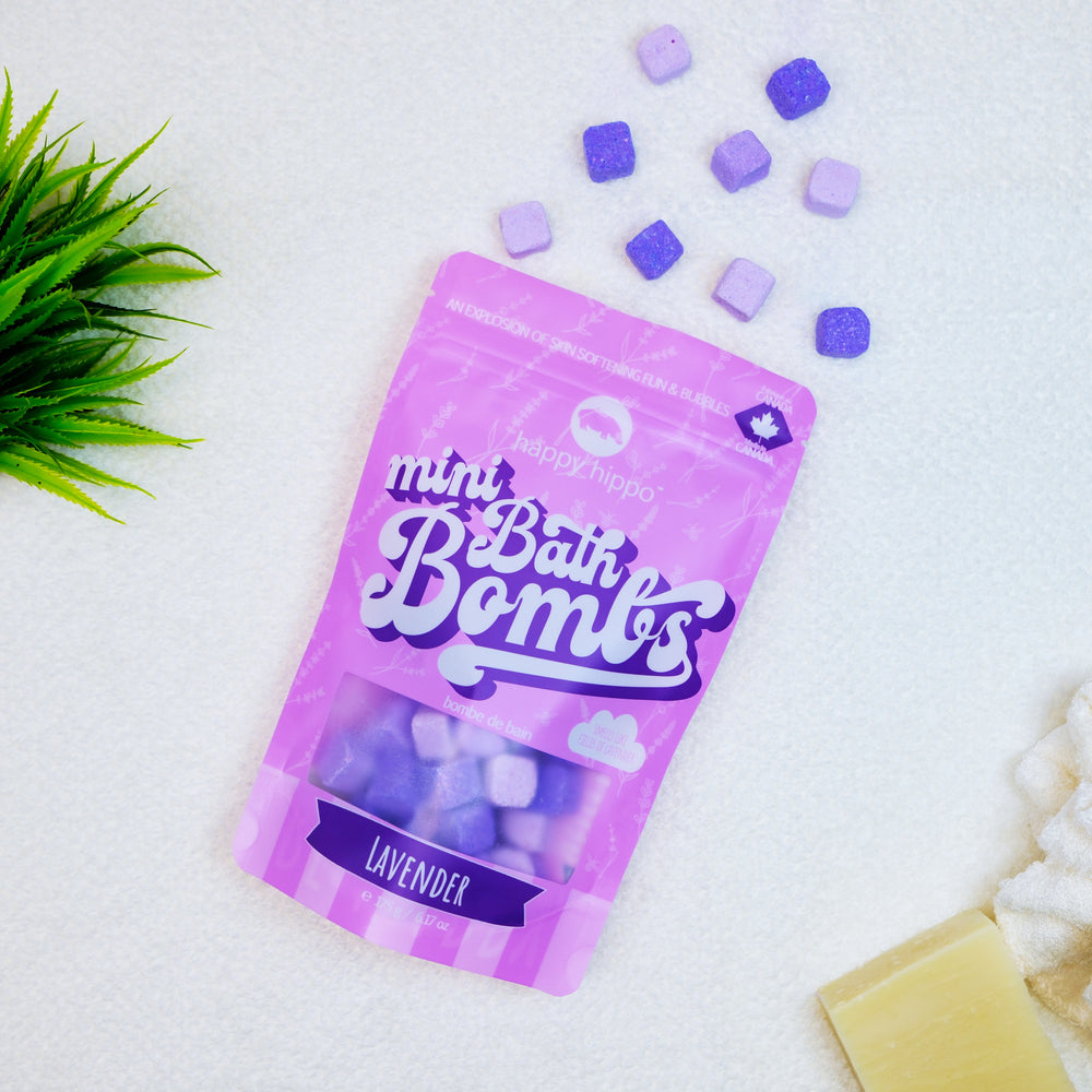 Purple package of lavender bath bombs on a white background with bath bombs and soap visible.