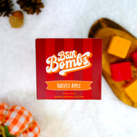 Box of Harvest Apple bath bombs on a white surface with decorative elements.